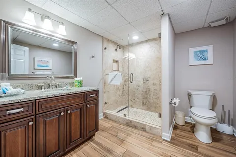 a bathroom with a granite countertop sink toilet and shower