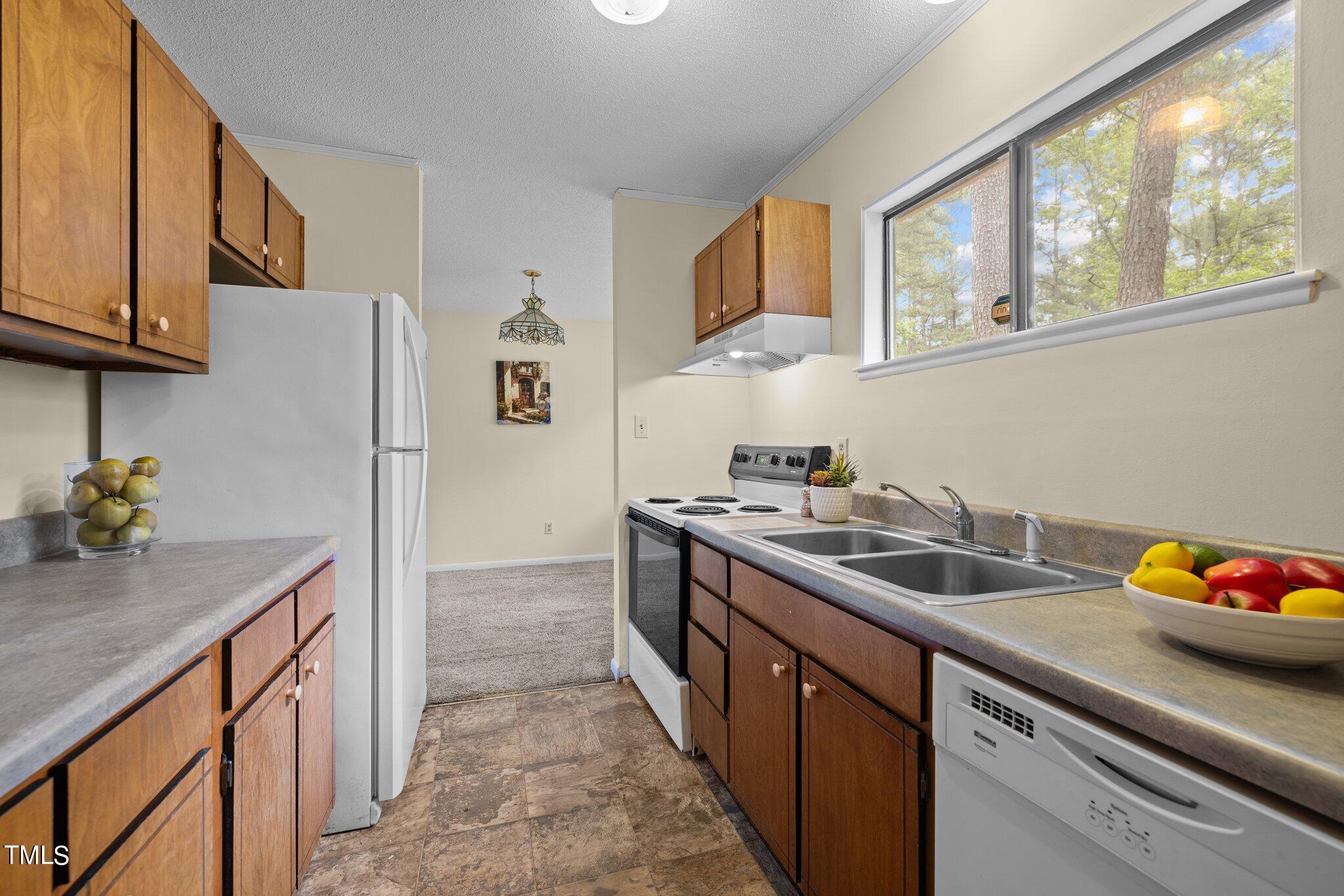 708 Godwin Court Raleigh, NC 27606 - Photo 17 of 48 a kitchen with stainless steel appliances granite countertop a sink stove and refrigerator