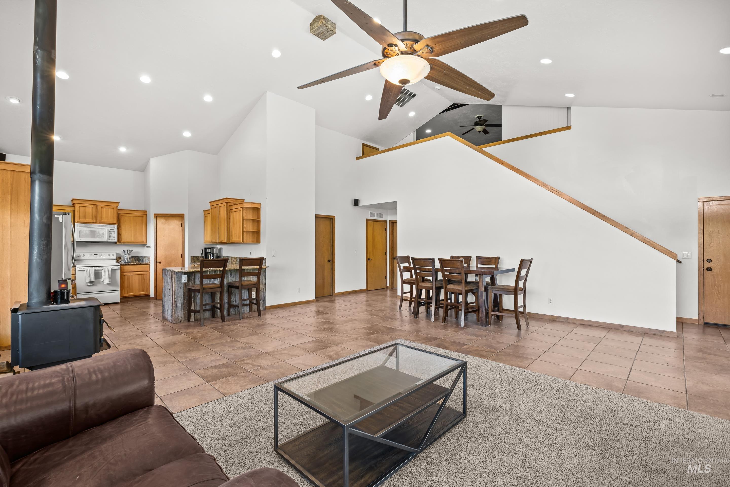 92 Cruickshank Road Horseshoe Bend, ID 83629 - Photo 9 of 50 Spacious living area featuring vaulted ceilings, recessed lighting, and a prominent wood-burning stove