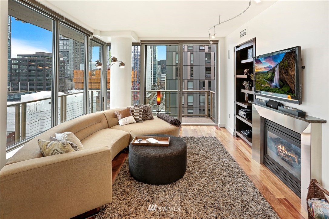 910 Lenora Street, Unit S1203 Seattle, WA 98121 - Photo 13 of 39 a living room with couches a flat screen tv and a floor to ceiling window