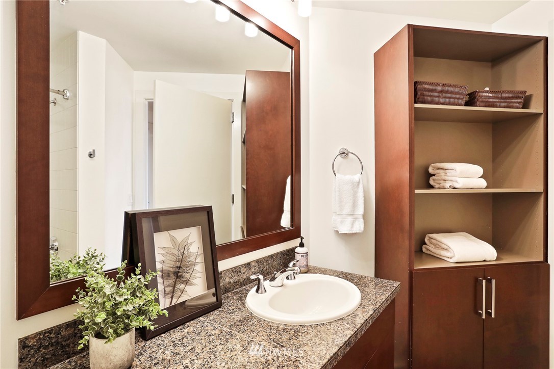 910 Lenora Street, Unit S1203 Seattle, WA 98121 - Photo 18 of 39 a bathroom with a granite countertop sink and a mirror