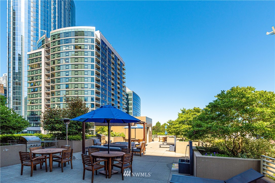910 Lenora Street, Unit S1203 Seattle, WA 98121 - Photo 24 of 39 a view of a patio with a table and chairs under an umbrella