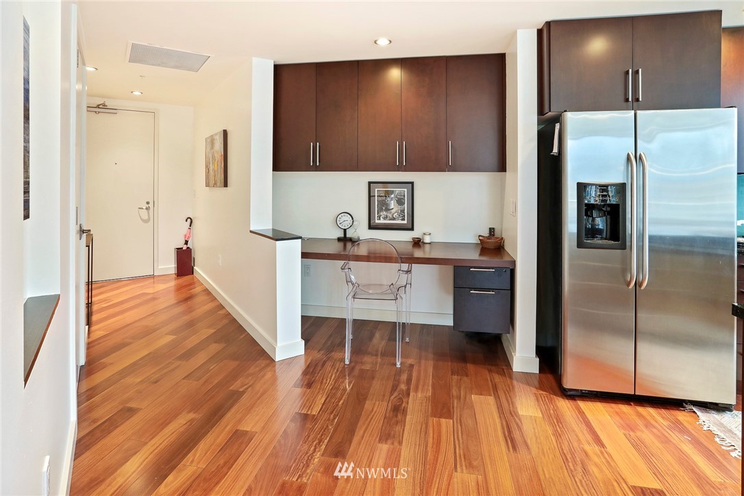 910 Lenora Street, Unit S1203 Seattle, WA 98121 - Photo 5 of 39 a kitchen with stainless steel appliances a refrigerator and wooden floor
