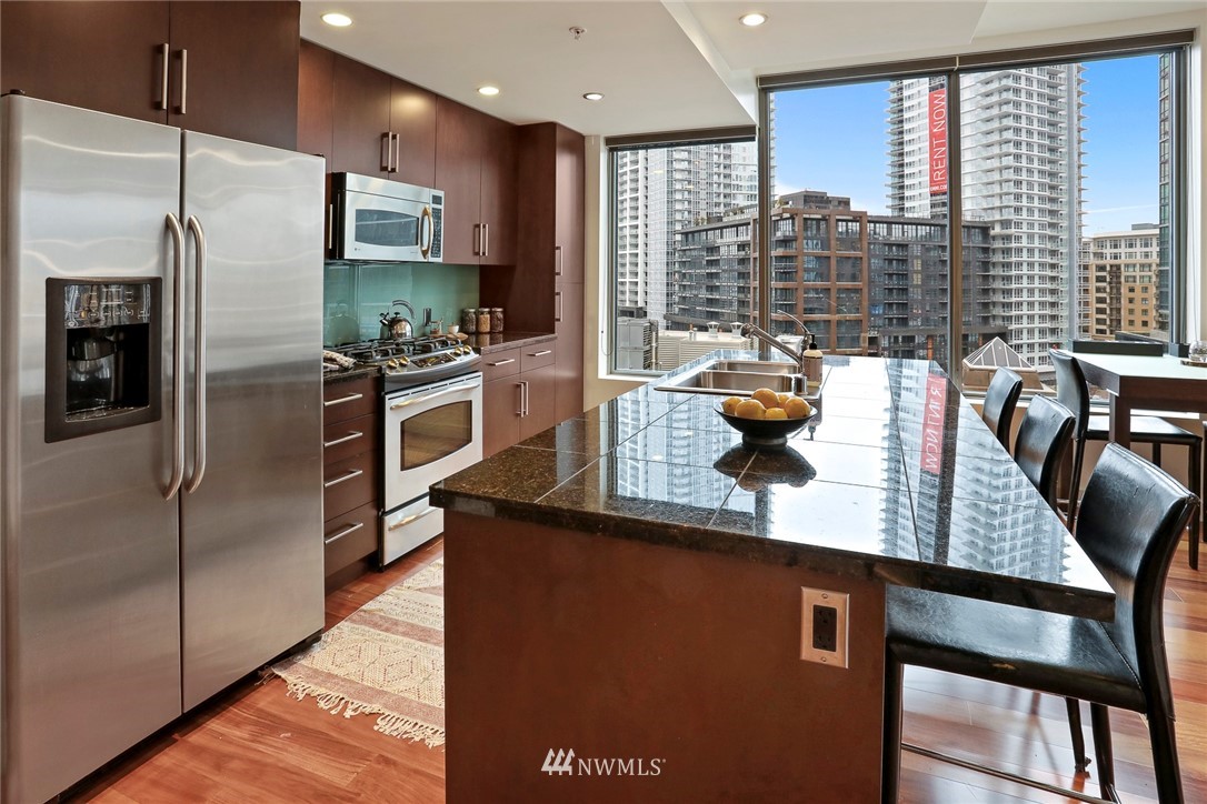 910 Lenora Street, Unit S1203 Seattle, WA 98121 - Photo 8 of 39 a kitchen with stainless steel appliances granite countertop a refrigerator a sink and a stove