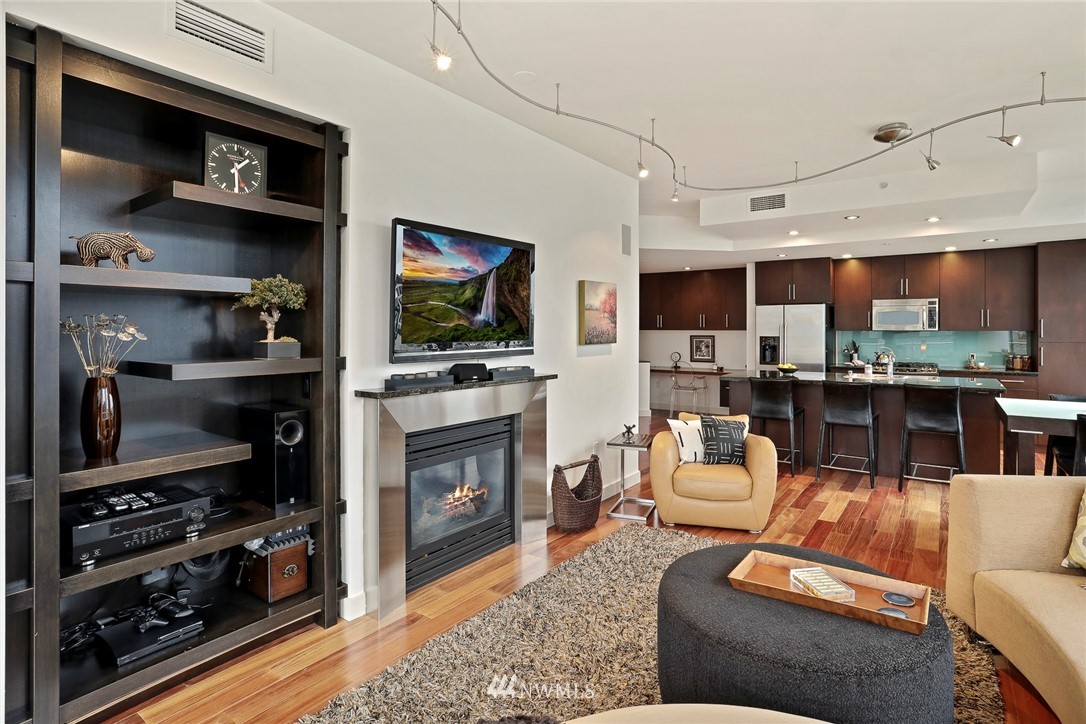 910 Lenora Street, Unit S1203 Seattle, WA 98121 - Photo 10 of 39 a living room with furniture a flat screen tv and a fireplace