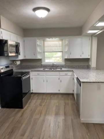 a kitchen with stainless steel appliances granite countertop a stove a sink dishwasher and a refrigerator