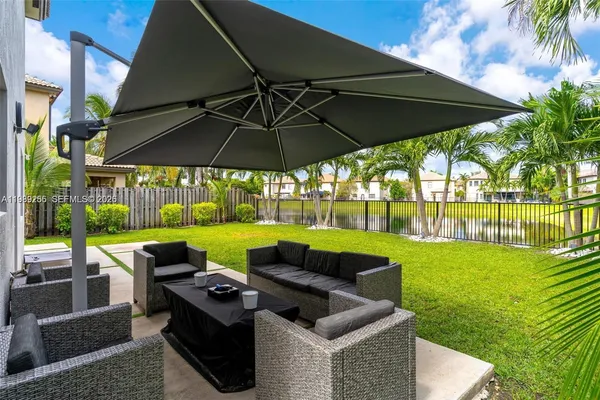 a view of pool with seating area and green space