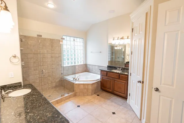 a bathroom with a granite countertop sink a toilet a mirror and shower