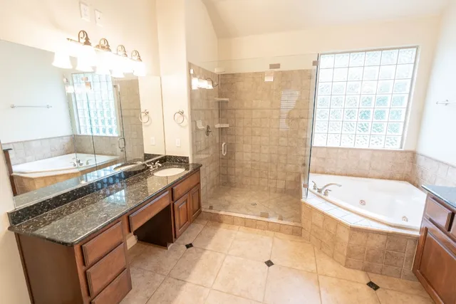 a bathroom with a granite countertop sink a toilet a bathtub and shower