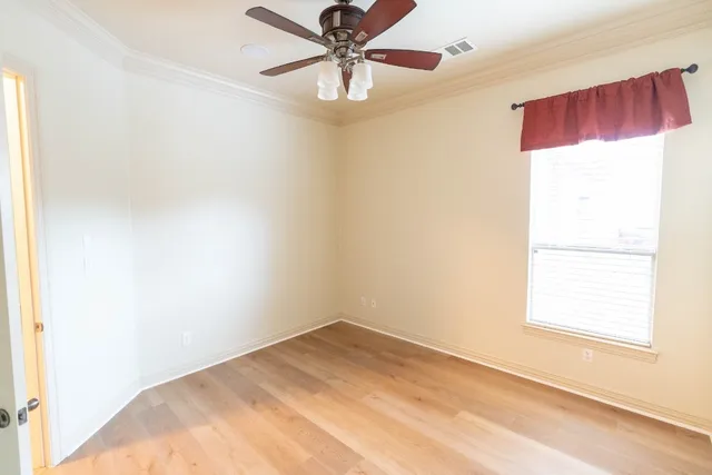 an empty room with a window and a fan