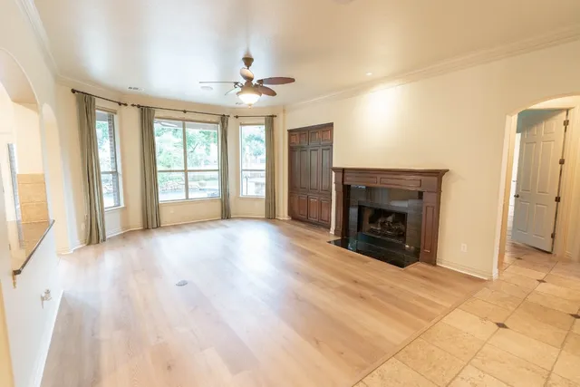 a view of an empty room with a fireplace and a window