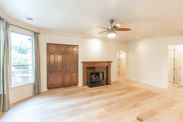 a view of an empty room with a fireplace and a window