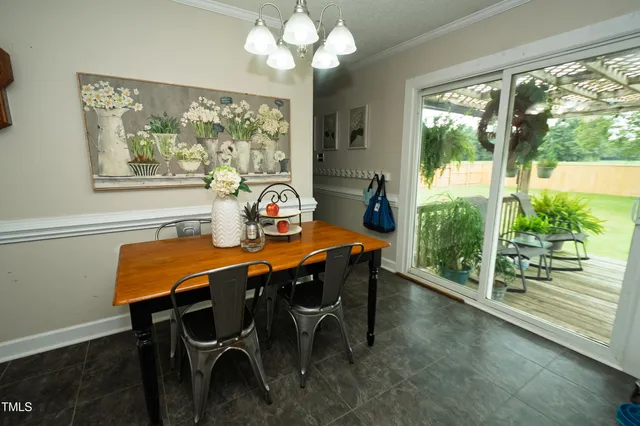 a dining room with furniture a large window and potted plants