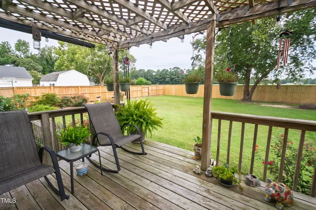 a view of a balcony with chairs and wooden floor