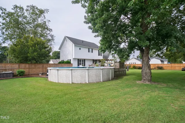 a view of a house with a yard and tree