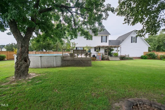 a view of a house with backyard and a tree