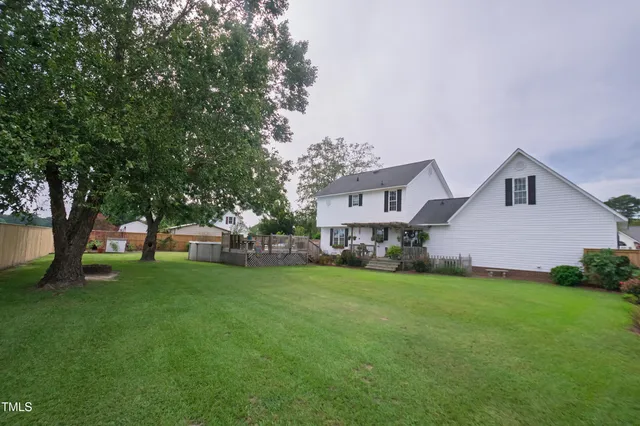 a front view of a house with a garden and trees