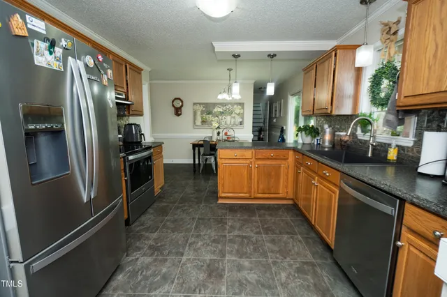 a kitchen with stainless steel appliances a refrigerator sink and stove