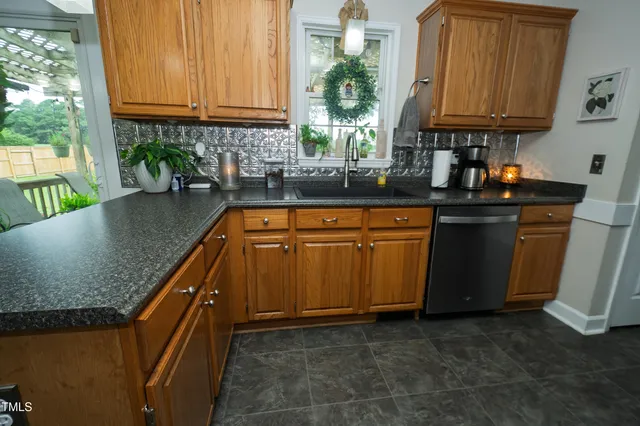 a kitchen with granite countertop a sink a counter space and cabinets
