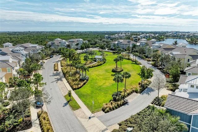 a view of a building next to a big yard and large trees