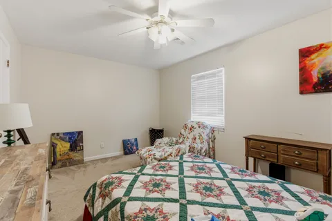 a bed sitting in a bedroom next to a window with a dresser