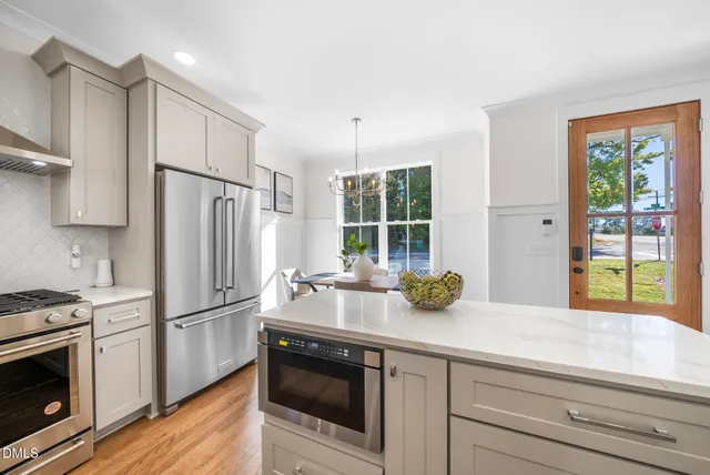 a kitchen with stainless steel appliances a sink stove and cabinets
