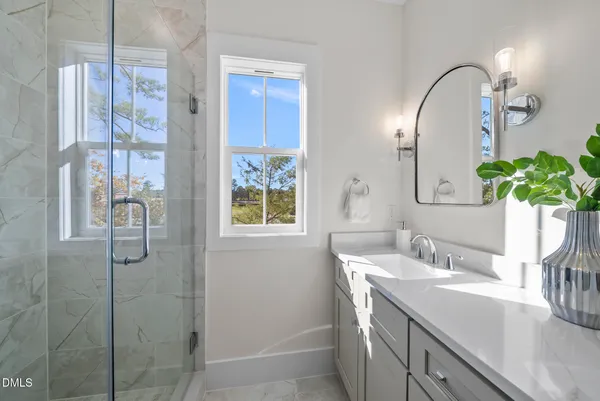 a bathroom with a granite countertop sink a mirror and a potted plant