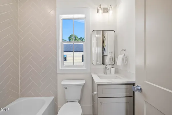 a bedroom with a bed and a lamp on dresser