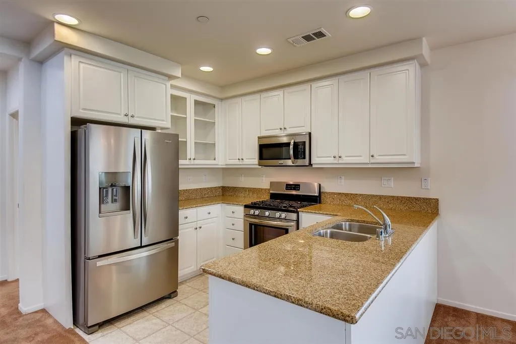 1435 Santa Diana Road, Unit 9 Chula Vista, CA 91913 - Photo 7 of 23 a kitchen with stainless steel appliances granite countertop a refrigerator stove microwave and sink