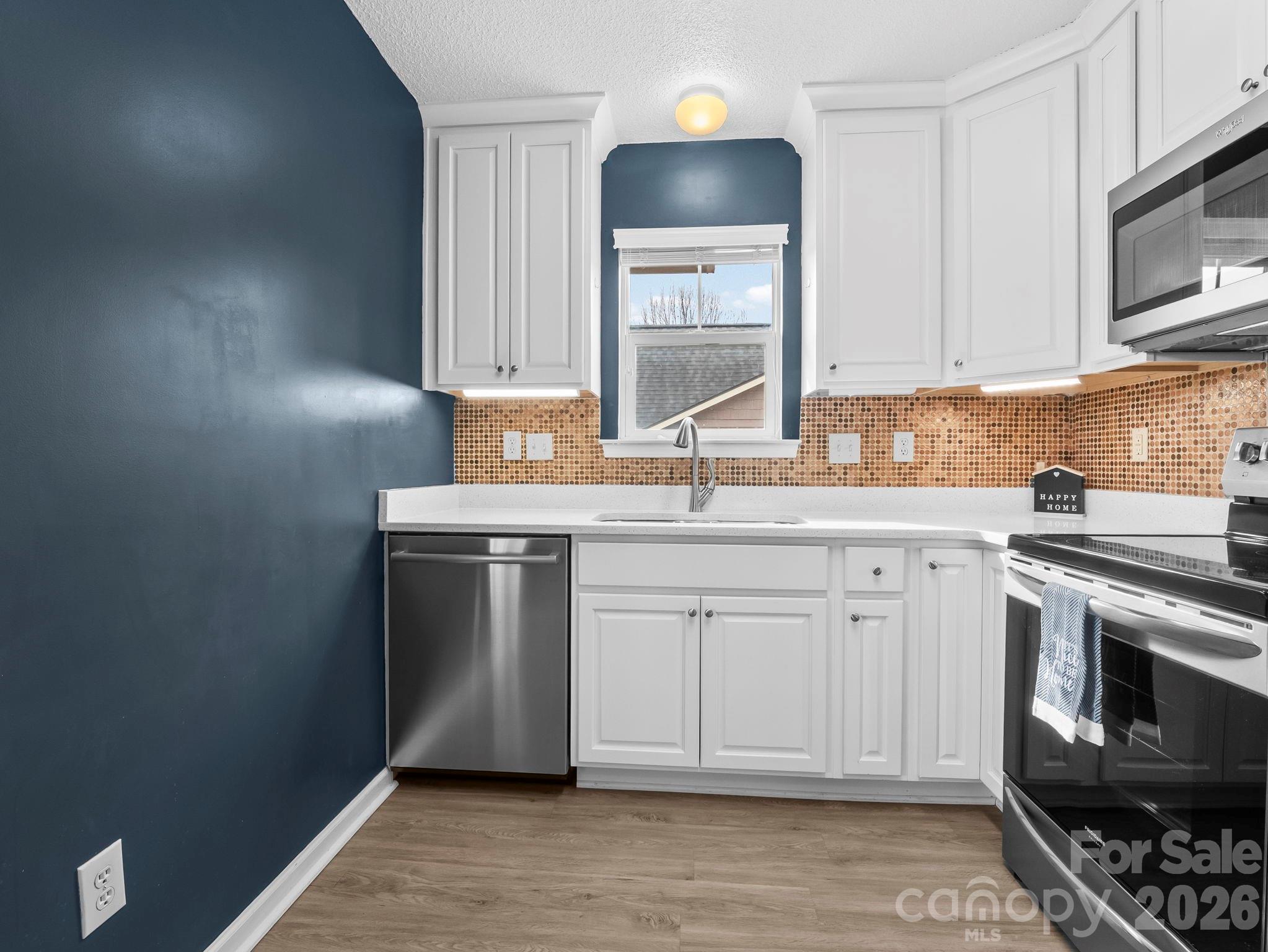 1002 Deermouse Way Hendersonville, NC 28792 - Photo 15 of 42 a kitchen with stainless steel appliances granite countertop a sink stove and microwave