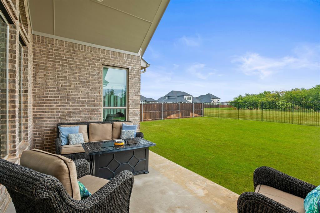 11504 Antler Ridge Way Argyle, TX 76226 - Photo 30 of 40 LARGE Covered patio showing partial view of the backyard and the greenbelt behind the home.