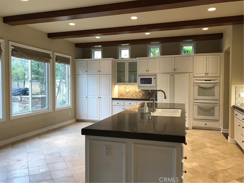 3 Garnet Irvine, CA 92620 - Photo 5 of 15 a kitchen with kitchen island a counter appliances a sink and cabinets