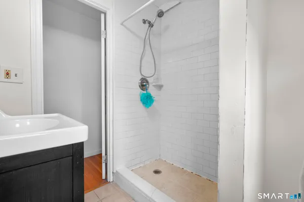 a bathroom with a shower a sink and a mirror
