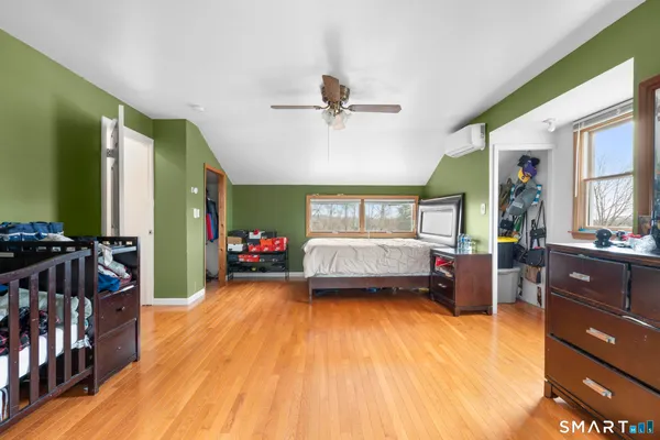 a view of a bedroom with furniture window and wooden floor