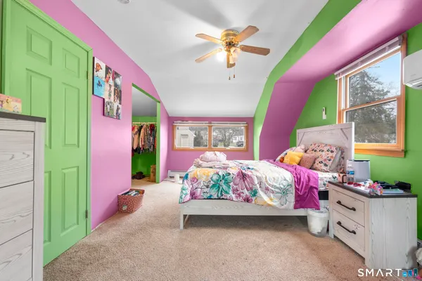 a bedroom with a bed and a painting on the wall