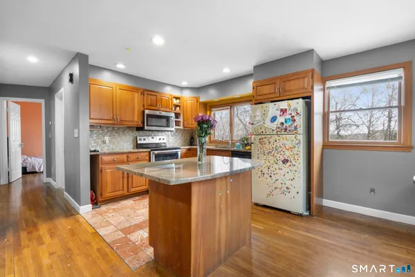 a kitchen with stainless steel appliances granite countertop a refrigerator a stove top oven a sink and dishwasher