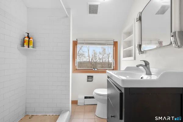 a bathroom with a sink toilet and window