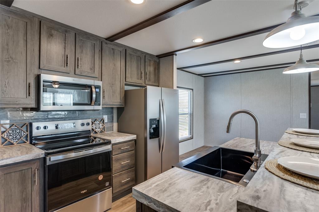 175 Cedar Drive Azle, TX 76020 - Photo 12 of 25 a kitchen with a refrigerator stove and sink