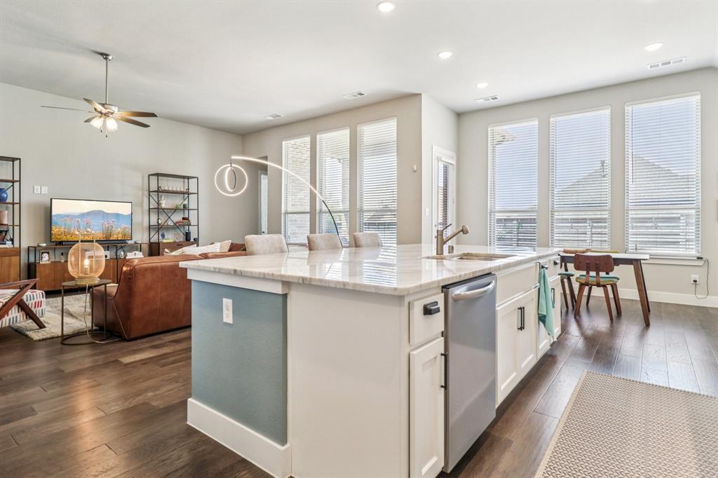 847 Longbranch Way Little Elm, TX 76227 - Photo 12 of 39 Kitchen featuring dark wood finished floors, white cabinets, recessed lighting, a kitchen island with sink, and light stone countertops