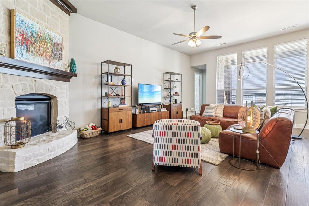 847 Longbranch Way Little Elm, TX 76227 - Photo 2 of 39 Living area with a stone fireplace, wood-type flooring, and a ceiling fan