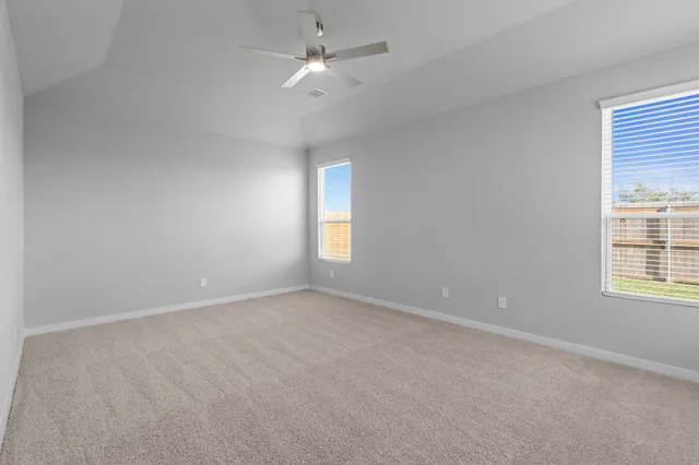 an empty room with a window and a ceiling fan