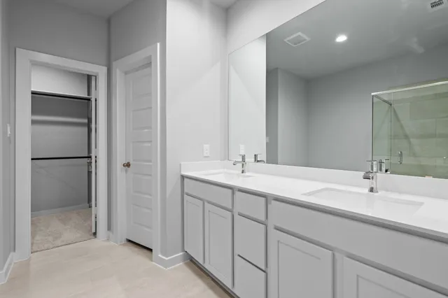 a bathroom with a double vanity sink mirror and shower