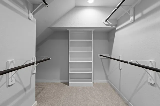 a view of walk in closet with empty racks