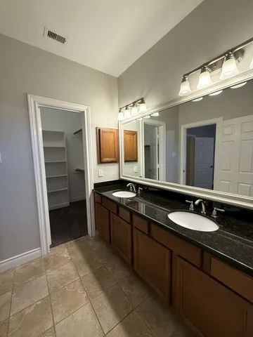 a spacious bathroom with a granite countertop sink and a mirror