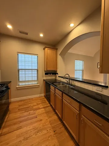 a large kitchen with kitchen island granite countertop a sink and a stove top oven