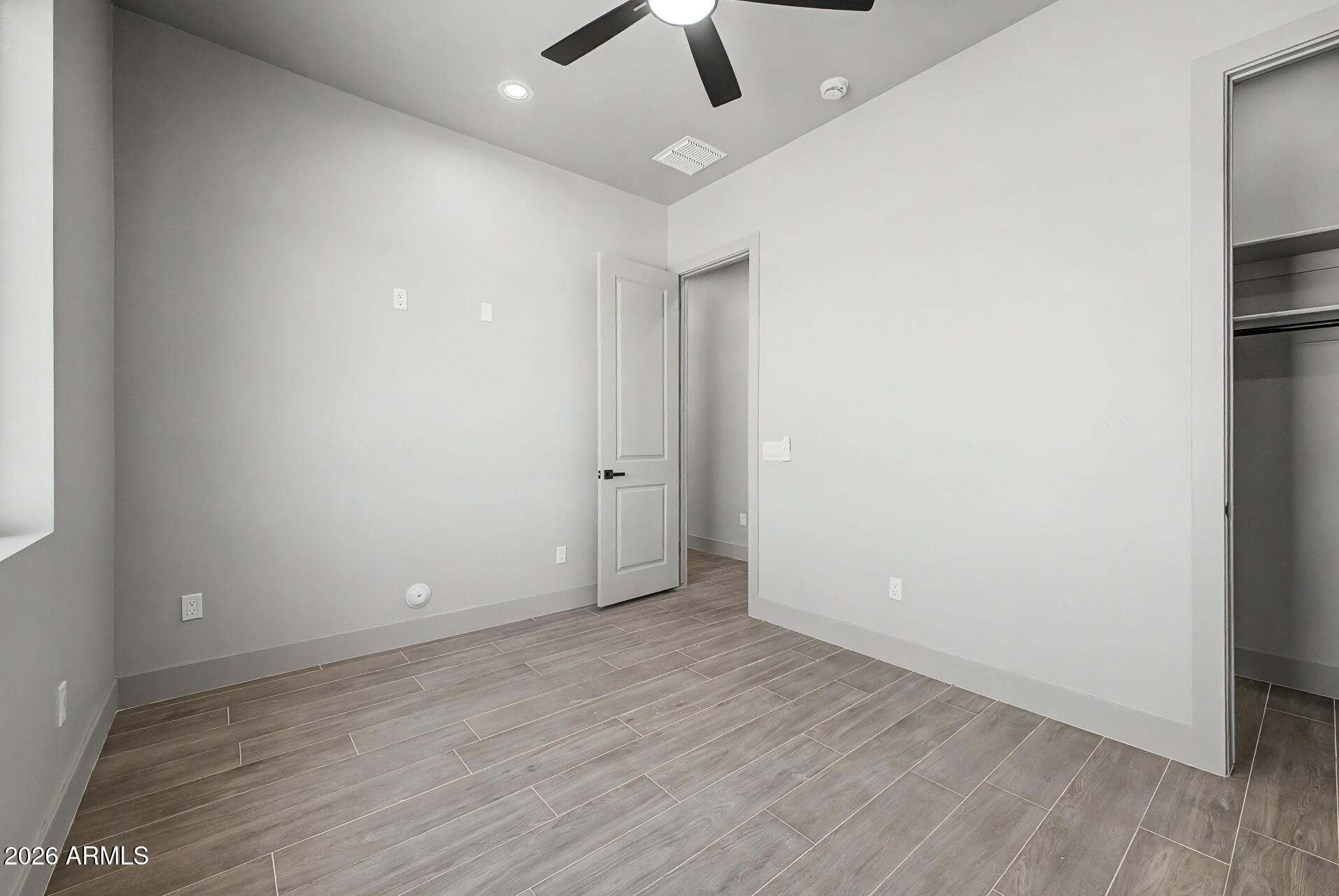 40461 West Robles Road Stanfield, AZ 85172 - Photo 42 of 54 an empty room with a ceiling fan and hardwood floor