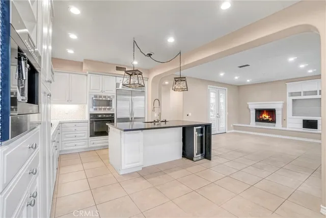a large kitchen with stainless steel appliances kitchen island granite countertop a large counter top and a sink