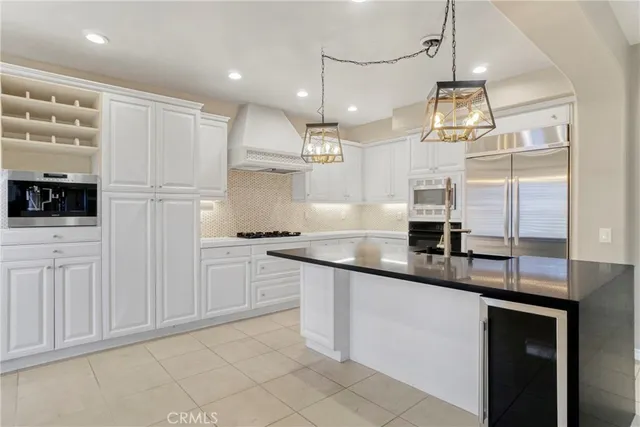 a kitchen with stainless steel appliances granite countertop a sink a stove and a refrigerator