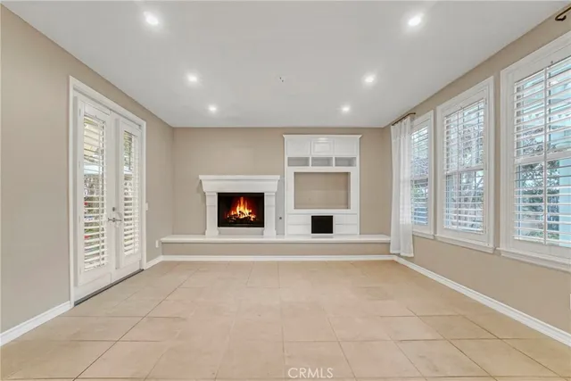 an empty room with windows and fireplace