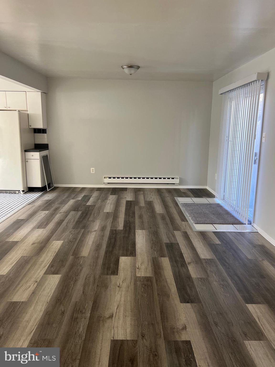 55 Noble Road Sicklerville, NJ 08081 - Photo 2 of 22 a view of an empty room and kitchen stove wooden floor and window